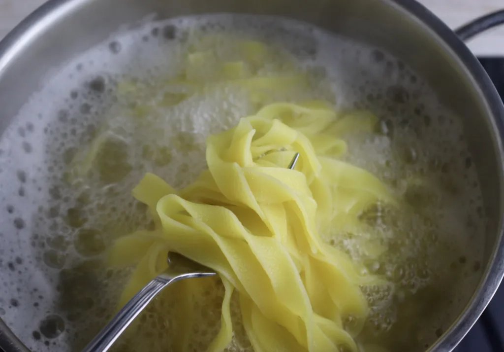 how to know when pasta is cooked enough - use a fork to lift the pasta from the water and try it
