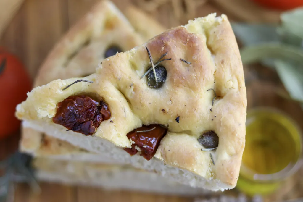 a crunchy piece of focaccia with sun dried tomatoes, capers and rosemary 