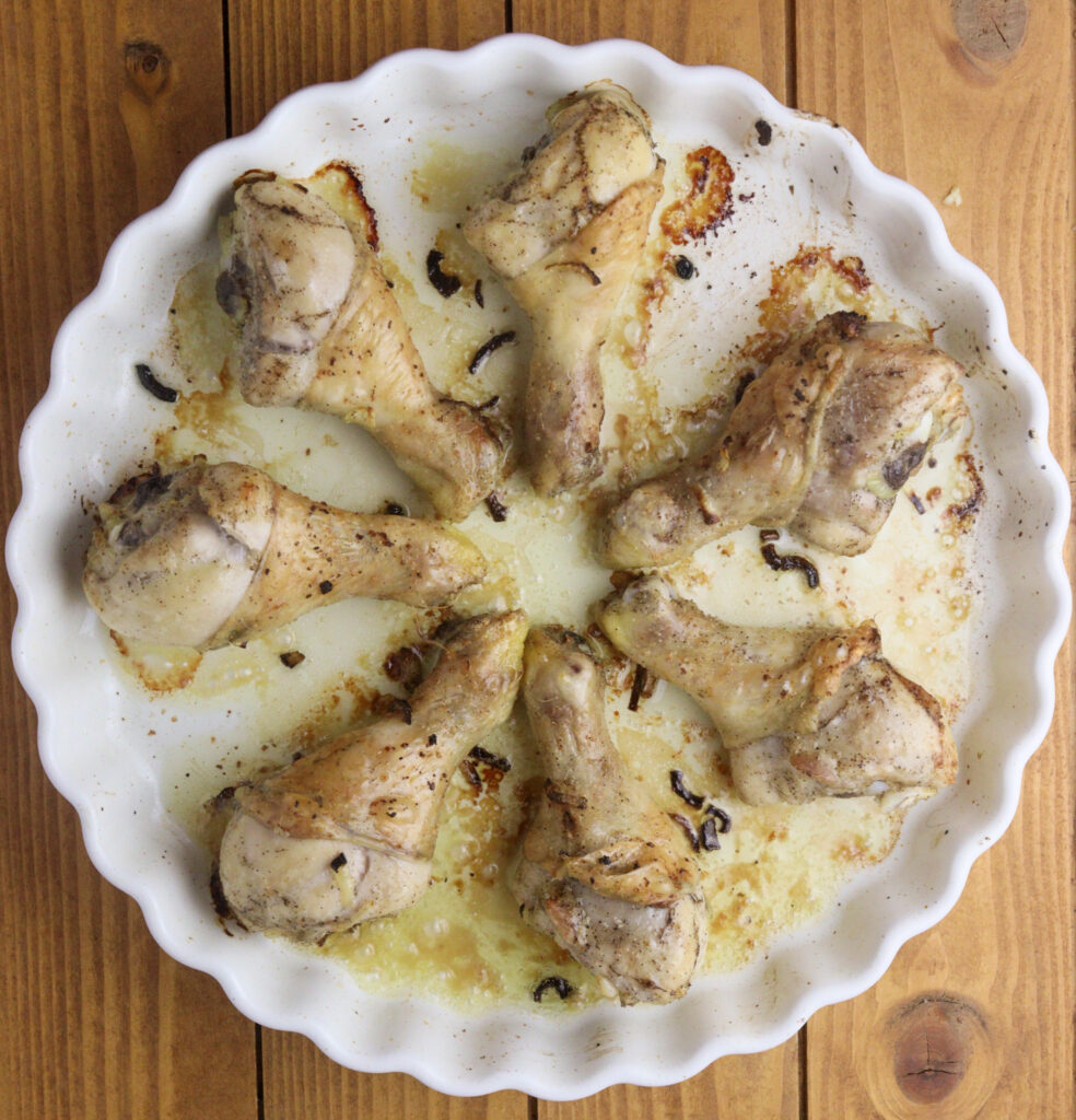 Image showing how to add the potato batter to the pan together with half baked chicken drumsticks