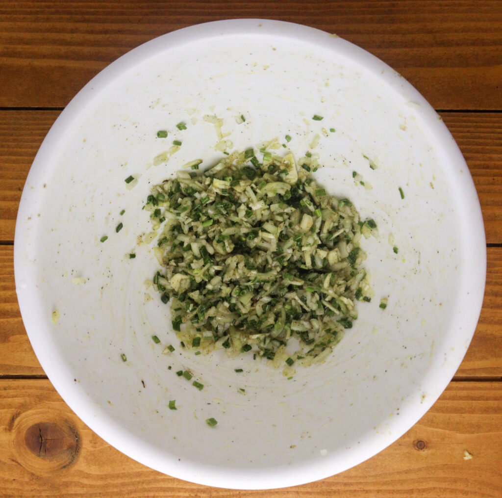 preparing seasoning for shredded potatoes with onions, salt, black pepper and dried chives