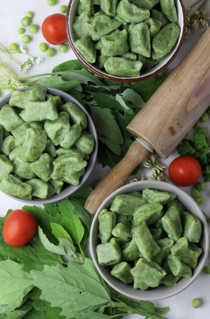 image of green gnocchi with wild spinach, other greens and cherry tomatoes 